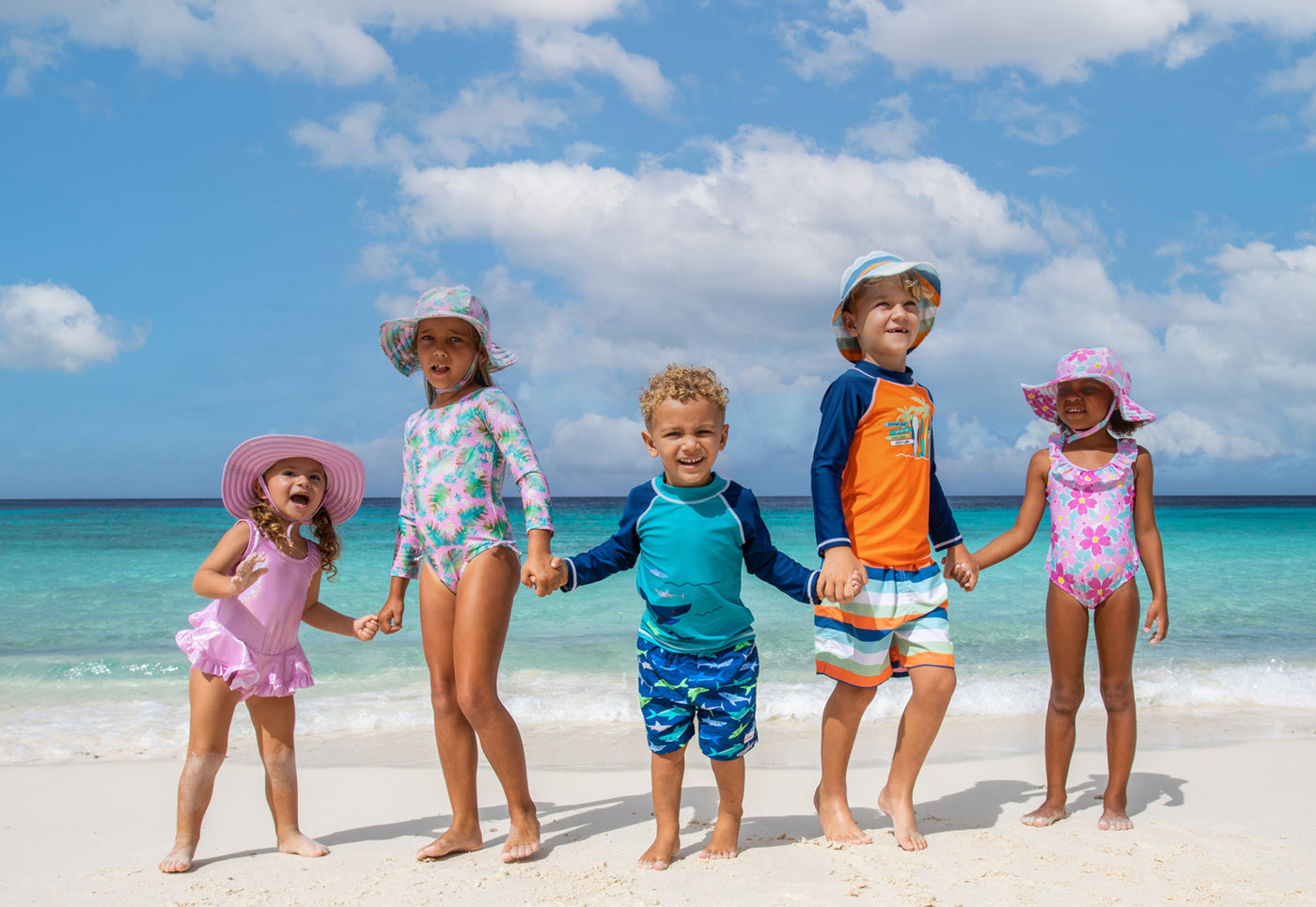 kids wearing flap happy on the beach holding hands